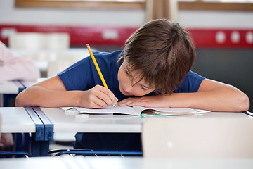 Image showing Elementary Boy Writing At Desk