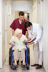 Image showing Medical Professionals With Patient In Corridor
