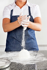 Image showing Female Chef Adding Flour To Dough