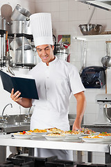 Image showing Chef With Checklist And Pasta Dishes At Counter