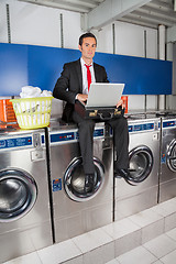 Image showing Businessman With Laptop In Laundry