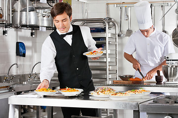 Image showing Waiter And Chef Working In Commercial Kitchen