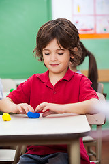 Image showing Boy Molding Clay At Desk