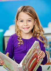 Image showing Girl Smiling While Holding Book In Kindergarten