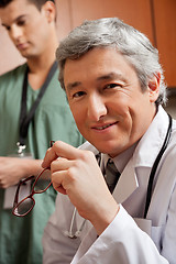 Image showing Mature Doctor Holding Glasses