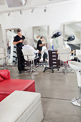 Image showing Hairstylist Ironing Customer's Hair