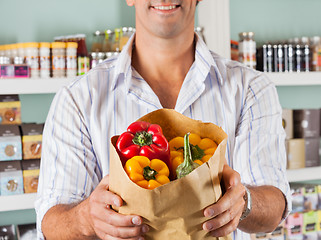 Image showing Male Customer Showing Bellpeppers In Paper Bag