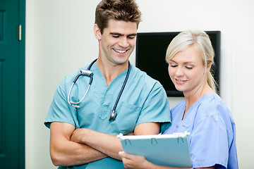 Image showing Young Female Nurse Showing Clipboard To Male Vet