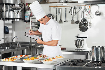 Image showing Chef With Clipboard Going Through Cooking Checklist