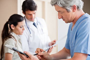 Image showing Doctor Writing On Clipboard