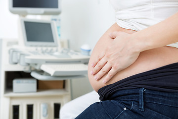 Image showing Pregnant Woman Touching Her Stomach In Clinic