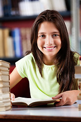 Image showing Happy Schoolgirl Sitting At Table In Library