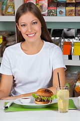 Image showing Young Woman With Burger And Drink At Table