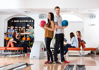 Image showing Young Man And Woman Holding Bowling Balls in Club