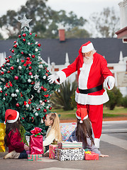 Image showing Santa Claus Gesturing At Children By Christmas Tree