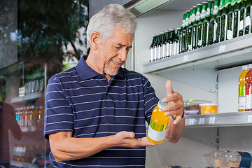 Image showing Senior Male Customer Buying Juice Bottle