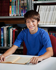 Image showing Teenage Male Student Sitting At Table In Library