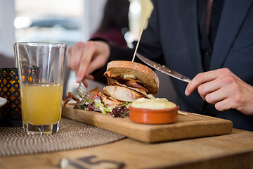 Image showing Young Businessman Having Sandwich In Cafe