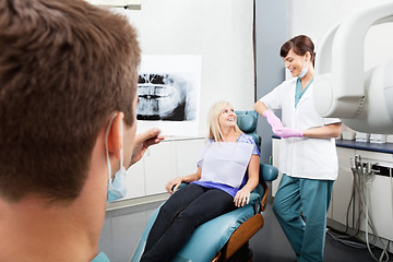 Image showing Dentist Examining X-Ray Image With Female Assistant Communicatin