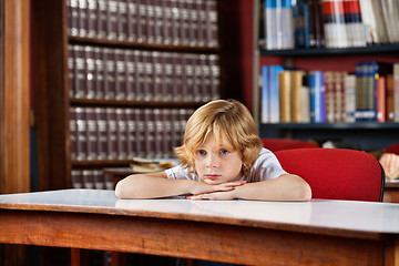 Image showing Schoolboy Looking Away While Leaning On Table