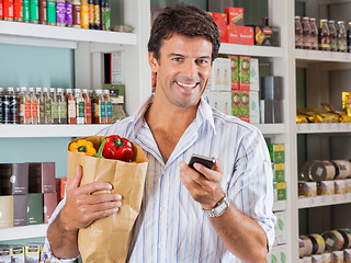 Image showing Man With Mobile Phone And Grocery Paper Bag