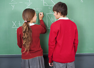 Image showing Students Looking At Each Other While Writing On Board