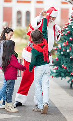 Image showing Boy Giving High Five To Santa Claus