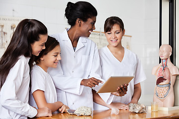 Image showing Teacher Using Digital Tablet With Students At Desk