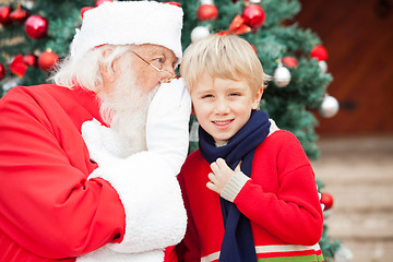 Image showing Santa Claus Whispering In Boy's Ear