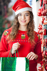 Image showing Woman In Santa Hat Carrying Shopping Bag