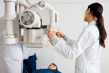 Image showing Female Radiologist Performing X-ray On Patient