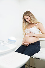 Image showing Pregnant Woman Caressing Belly In Clinic