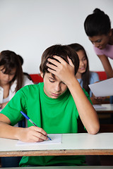 Image showing Sad Teenage Boy Writing Paper At Desk