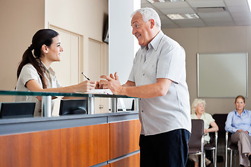 Image showing Man Communicating With Female Receptionist