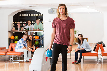 Image showing Young Man Holding Ball in Bowling Alley At Club