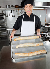 Image showing Male Chef Presenting Baked Bread Loafs