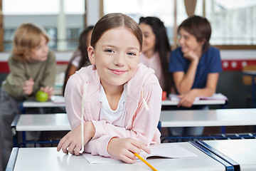 Image showing Schoolgirl Smiling While Leaning On Desk