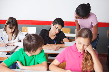 Image showing Teacher Assisting Teenage Schoolboy During Examination