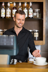 Image showing Barista Gesturing At Counter In Coffeeshop
