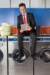 Image showing Businessman Using Digital Tablet In Laundry