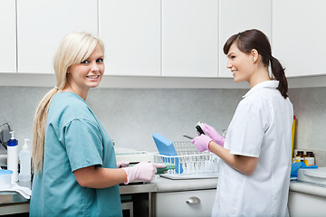 Image showing Smiling Dentist With Assistant Cleaning Medical Instruments At C