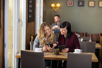 Image showing Female Friends Using Digital Tablets At Table