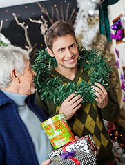 Image showing Man Holding Wreath Standing With Father At Christmas Store