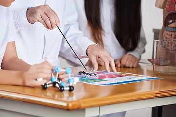 Image showing Male Teacher With Students Experimenting At Desk