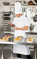 Image showing Chef With Clipboard Checking Pasta Dishes