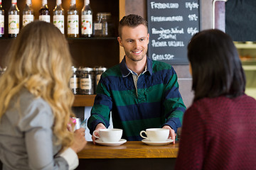 Image showing Bartender Serving Coffee To Female Friends At Cafe