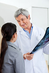 Image showing Radiologist Looking At Patient While Holding X-ray