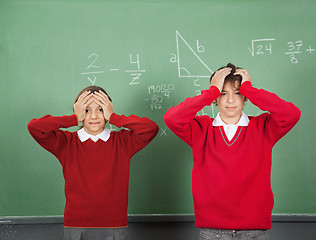 Image showing Confused Teenage Students Standing Against Board