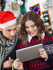 Image showing Couple Using Digital Tablet At Christmas Store