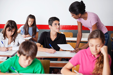 Image showing Teacher Assisting Teenage Boy